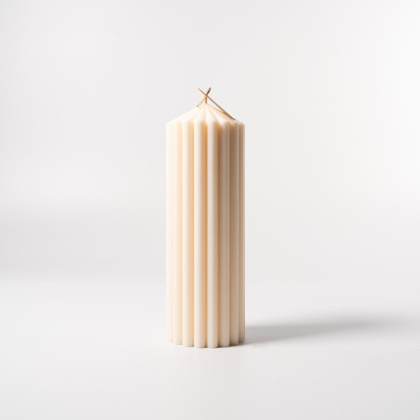 Stumpenkerze „Pure“ aus 100 % Sojawachs von WeFra-Candles, weiße Kerze mit glattem Oberteil auf einem Kerzenhalter.