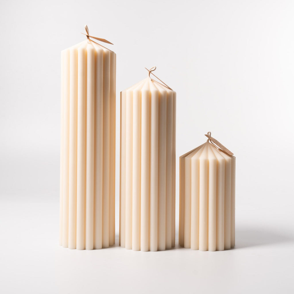 Stumpenkerze „Pure“ aus 100 % Sojawachs von WeFra-Candles, helles, schlichtes Design, brennend auf einer Kerzenhalter.