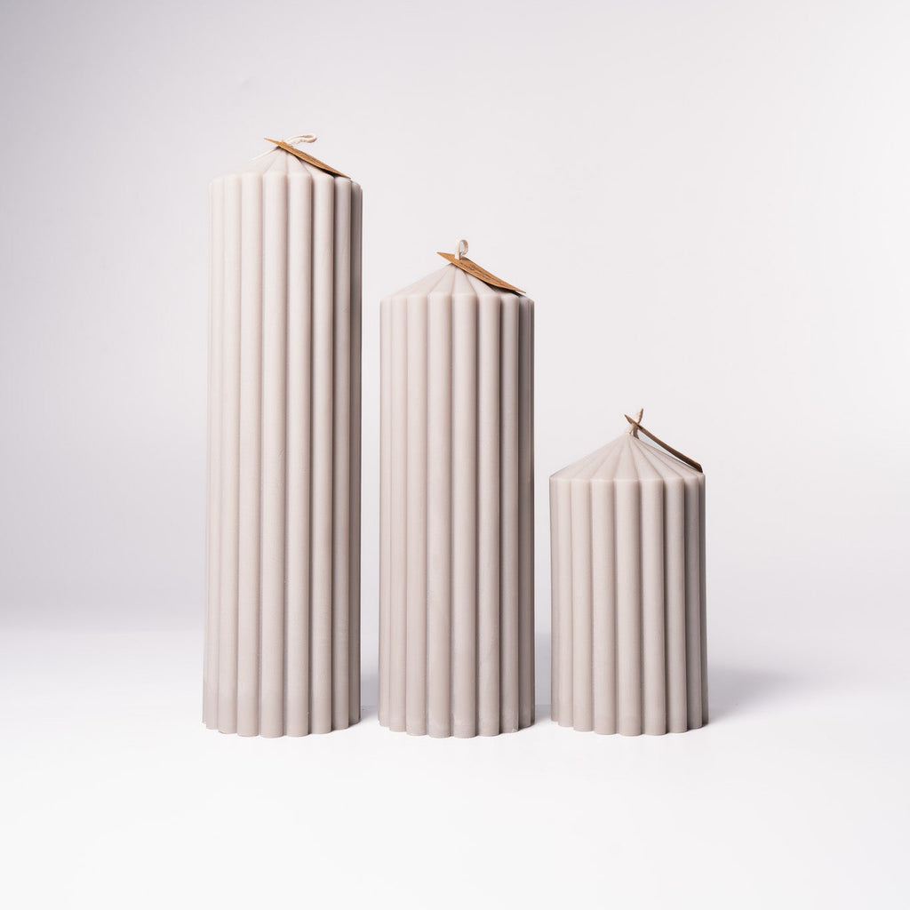 Stumpenkerze „Pure“ aus 100 % Sojawachs von WeFra-Candles, elegante weiße Kerze auf einem Kerzenständer.