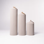 Stumpenkerze „Pure“ aus 100 % Sojawachs von WeFra-Candles, elegante weiße Kerze auf einem Kerzenständer.